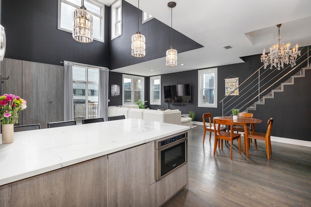 kitchen with a chandelier, oven, an accent wall, visible vents, and modern cabinets