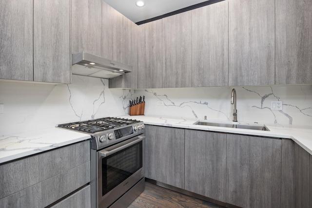 kitchen with extractor fan, a sink, gray cabinets, modern cabinets, and stainless steel range with gas stovetop