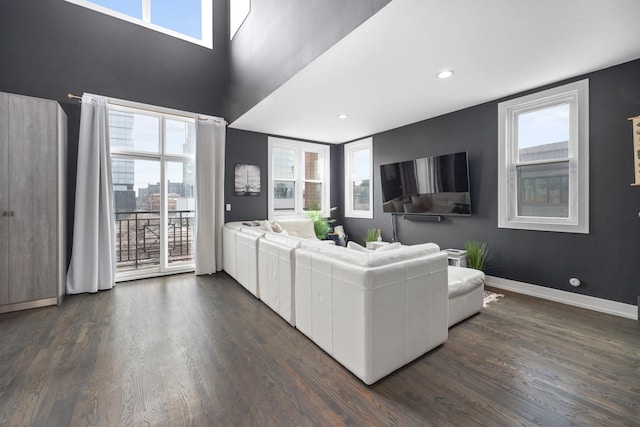 living area with dark wood-style floors, baseboards, and recessed lighting