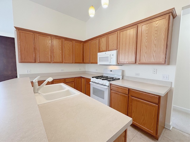 kitchen featuring white appliances, light tile patterned floors, vaulted ceiling, light countertops, and a sink