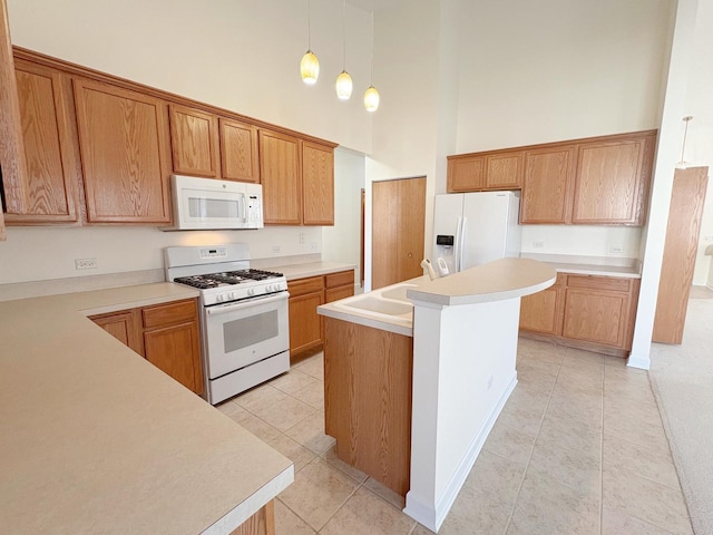 kitchen featuring light tile patterned floors, light countertops, a towering ceiling, a sink, and white appliances