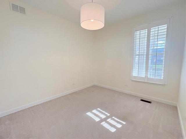 carpeted empty room with visible vents and baseboards