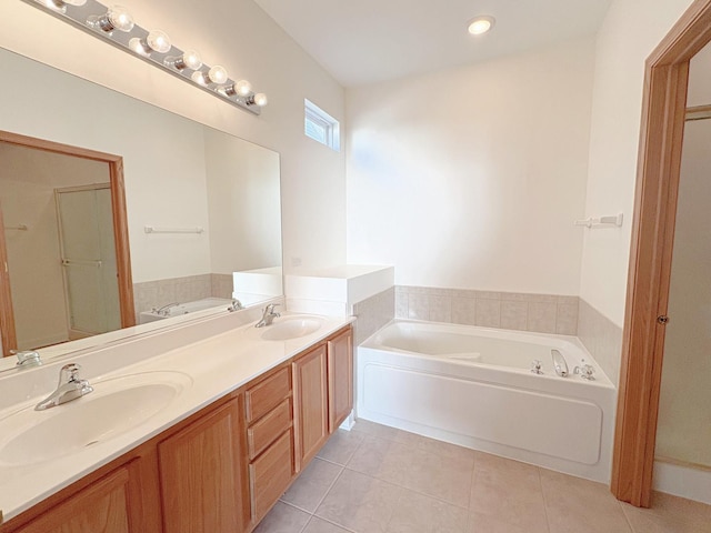 full bath featuring a garden tub, a sink, and tile patterned floors