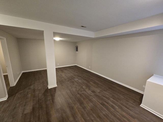 finished basement featuring dark wood finished floors, visible vents, and baseboards