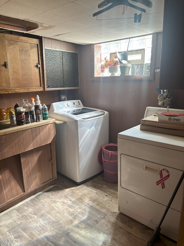 2820 W 84th St, Chicago, IL 60652 - laundry area with light wood-type flooring, wooden walls, cabinet space, and washer and clothes dryer