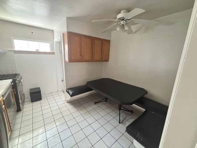 2820 W 84th St, Chicago, IL 60652 - kitchen with brown cabinets, ceiling fan, light tile patterned flooring, and stainless steel gas range