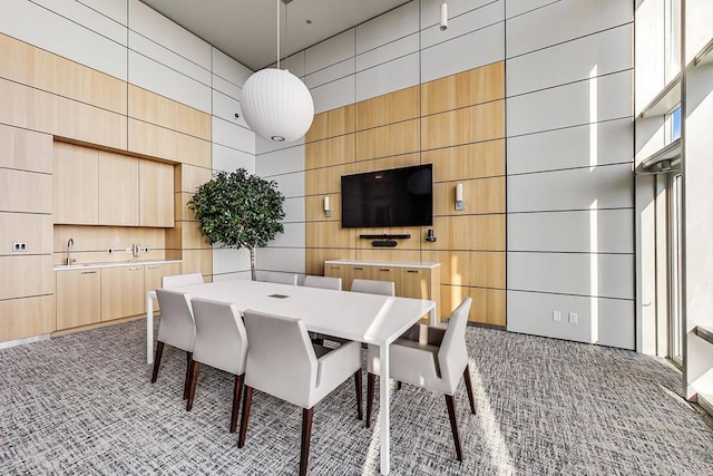 dining room featuring light carpet and a high ceiling