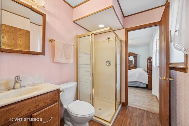 bathroom featuring toilet, a shower stall, wood finished floors, and vanity