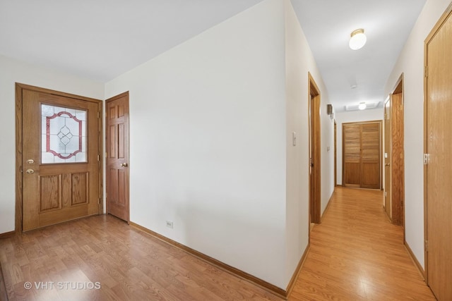 foyer entrance with light wood-type flooring and baseboards