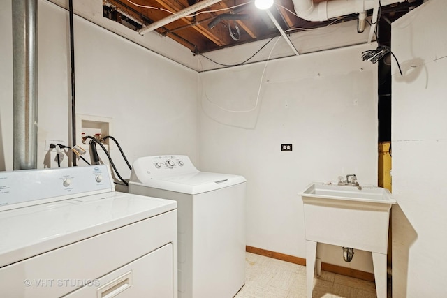 laundry area with laundry area, a sink, baseboards, independent washer and dryer, and light floors