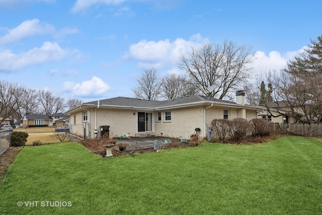 back of property with a fenced backyard, a chimney, a yard, a patio area, and brick siding