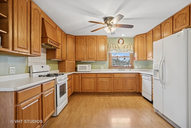 kitchen featuring white appliances, brown cabinets, light wood-style floors, open shelves, and a sink