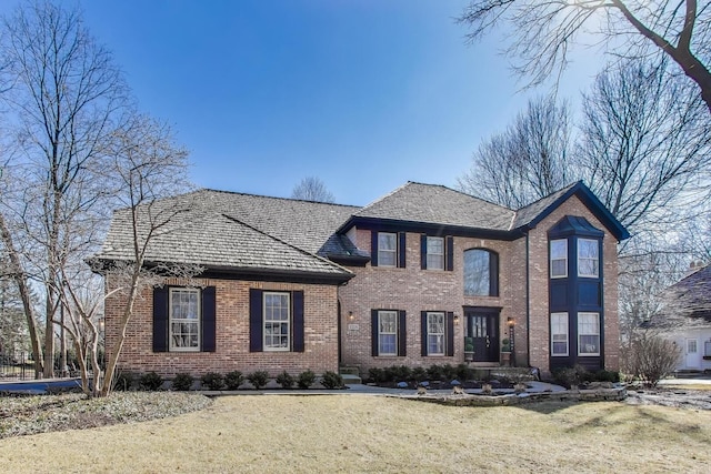 view of front facade featuring brick siding and a front yard