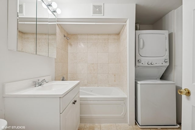 bathroom featuring stacked washer and dryer, visible vents, shower / bathing tub combination, vanity, and tile patterned flooring