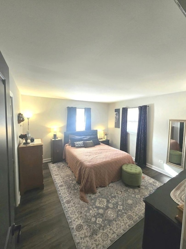 bedroom with baseboards and dark wood-type flooring