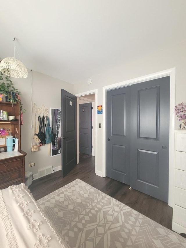 bedroom with visible vents, baseboards, and dark wood-style flooring