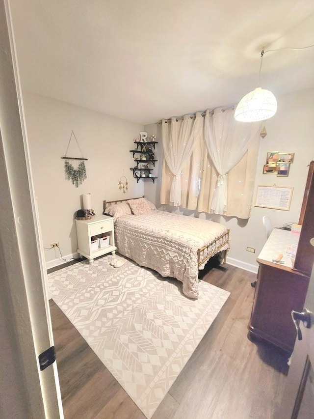 bedroom featuring baseboards and wood finished floors