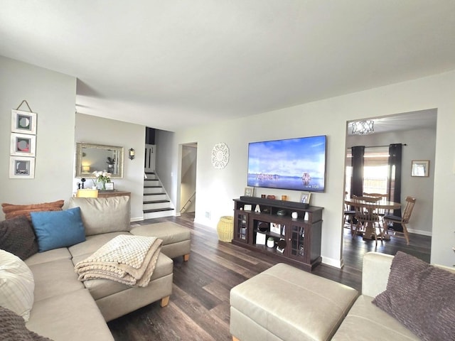 living room with stairway, baseboards, and wood finished floors