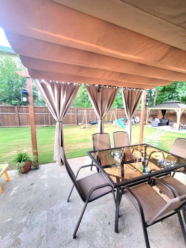 view of patio / terrace featuring a gazebo, a fenced backyard, and outdoor dining space