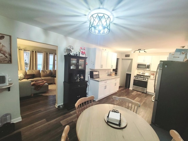 dining area with baseboards, a notable chandelier, and dark wood-style floors