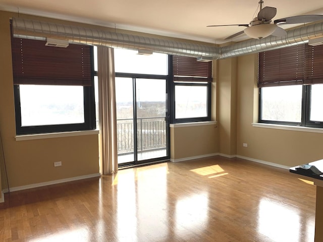 unfurnished room with ceiling fan, light wood-type flooring, and baseboards