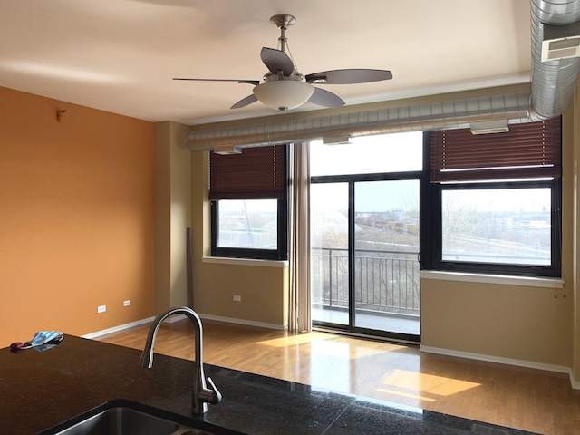 kitchen with baseboards, a sink, and wood finished floors