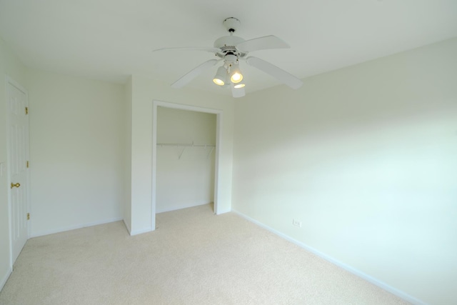 unfurnished bedroom with a ceiling fan, a closet, light colored carpet, and baseboards