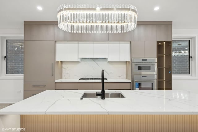 kitchen featuring stainless steel appliances, a sink, gray cabinets, decorative backsplash, and modern cabinets