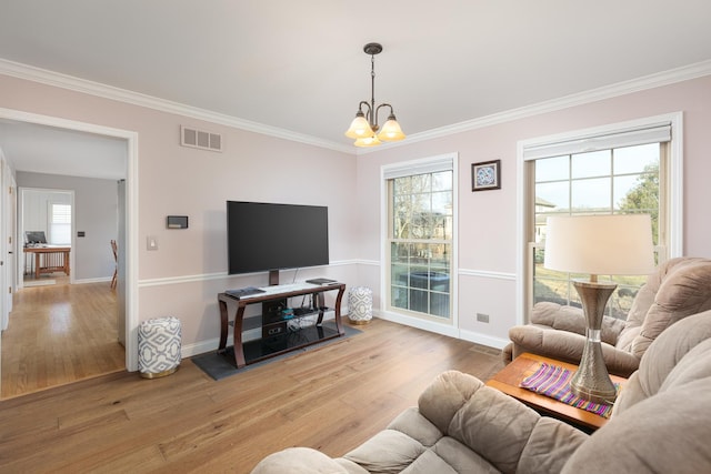 living room with ornamental molding, a wealth of natural light, visible vents, and wood finished floors