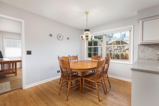 dining area with light wood finished floors and baseboards