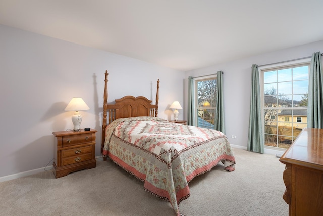 bedroom featuring light carpet and baseboards