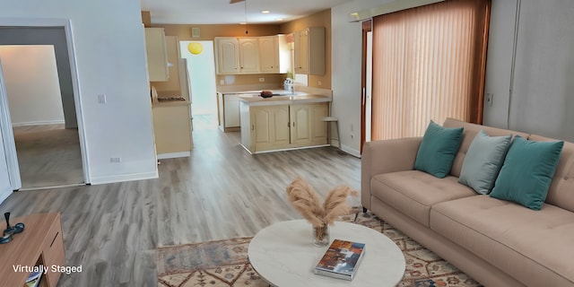 living room featuring recessed lighting, light wood-style flooring, and baseboards