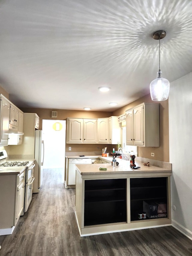 kitchen with pendant lighting, white appliances, a peninsula, and dark wood-style floors