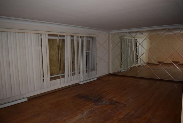 spare room with a baseboard radiator, ornamental molding, baseboard heating, and wood finished floors