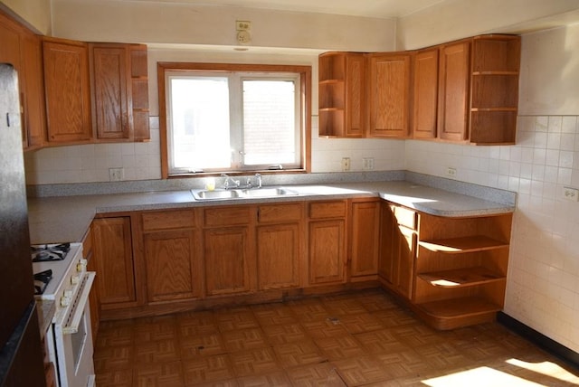 kitchen with open shelves, brown cabinets, a sink, and white range with gas cooktop