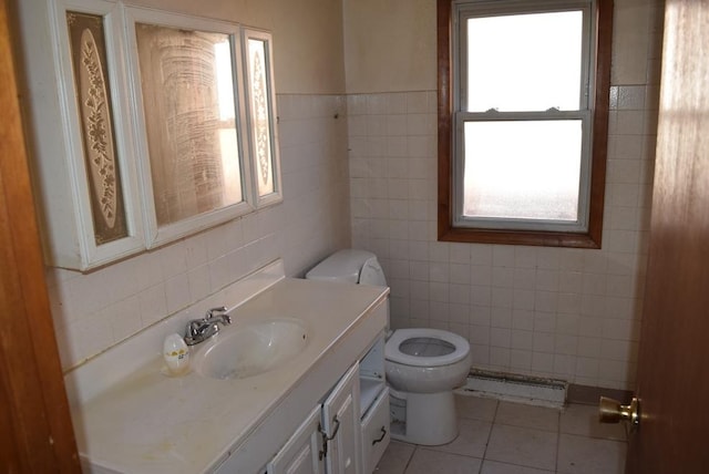 bathroom with a baseboard radiator, tile patterned flooring, toilet, vanity, and tile walls