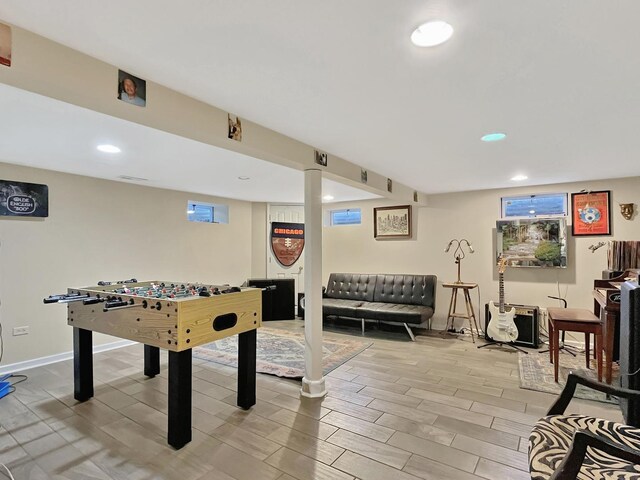 bedroom featuring light wood-type flooring, multiple windows, baseboards, and a ceiling fan