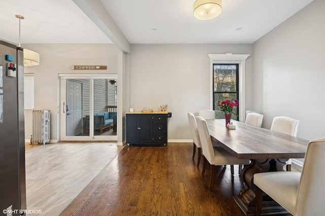 dining room featuring dark wood-type flooring, radiator, and baseboards