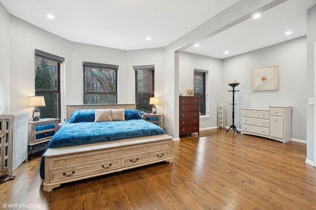 bedroom featuring recessed lighting, wood finished floors, and radiator