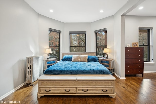 bedroom with radiator heating unit, baseboards, dark wood-type flooring, and recessed lighting