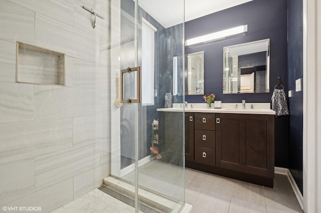 bathroom with double vanity, a stall shower, tile patterned flooring, and a sink