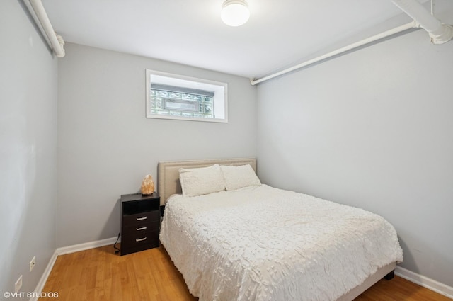 bedroom with baseboards and light wood finished floors