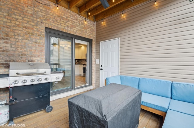 wooden terrace with an outdoor hangout area and a grill