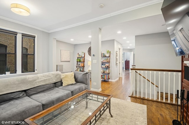 living room featuring crown molding, baseboards, wood finished floors, and recessed lighting