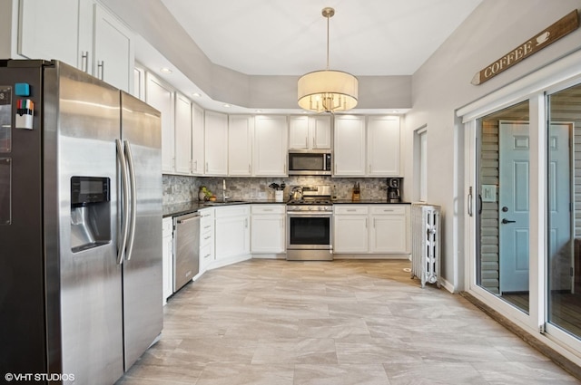 kitchen with dark countertops, tasteful backsplash, appliances with stainless steel finishes, and white cabinets