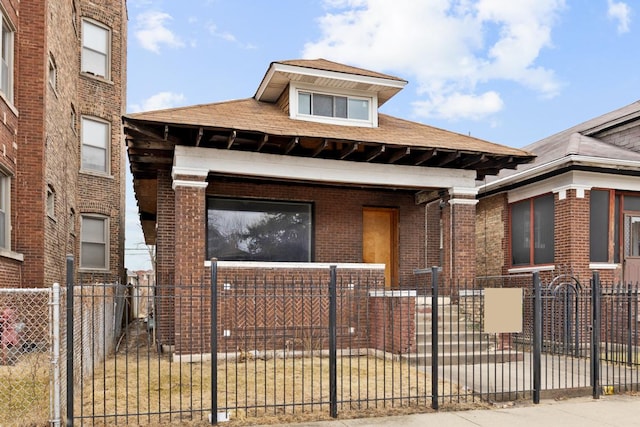 view of front of home with a fenced front yard and brick siding