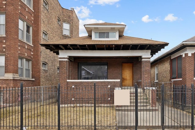 view of front of house with a fenced front yard, a gate, a porch, and brick siding