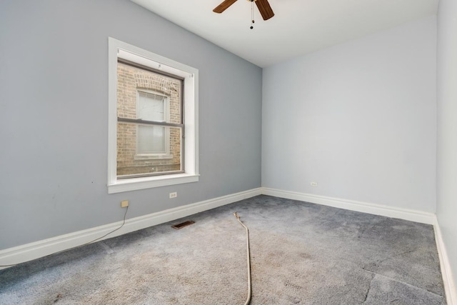 carpeted empty room with visible vents, baseboards, and ceiling fan