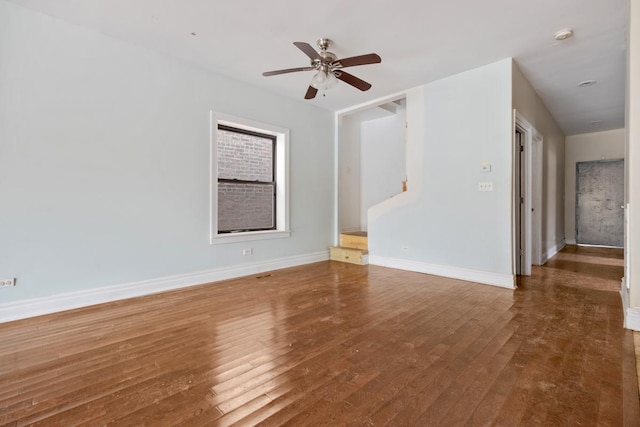 spare room featuring wood-type flooring, baseboards, and a ceiling fan