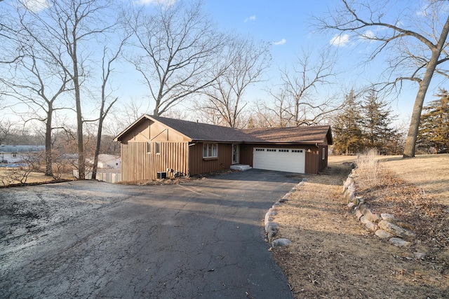 view of front of house featuring aphalt driveway, board and batten siding, and an attached garage